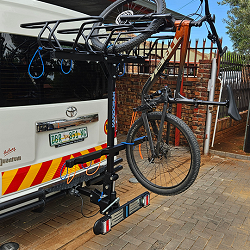 One bike on the back white van parked on a drive